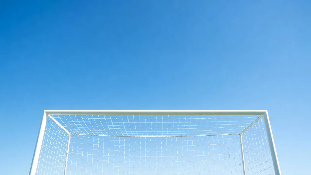 Trave e travessão brancos de um gol contra o céu azul, em ângulo baixo