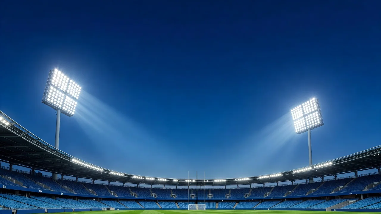 Refletores de estádio acesos contra o céu azul do entardecer