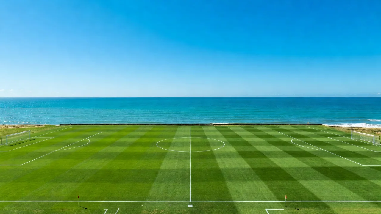 Campo de futebol costeiro perto do mar em Santos sob céu azul, vazio